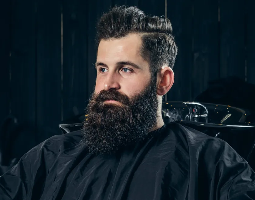 Uomo con barba folta e curata dal barbiere