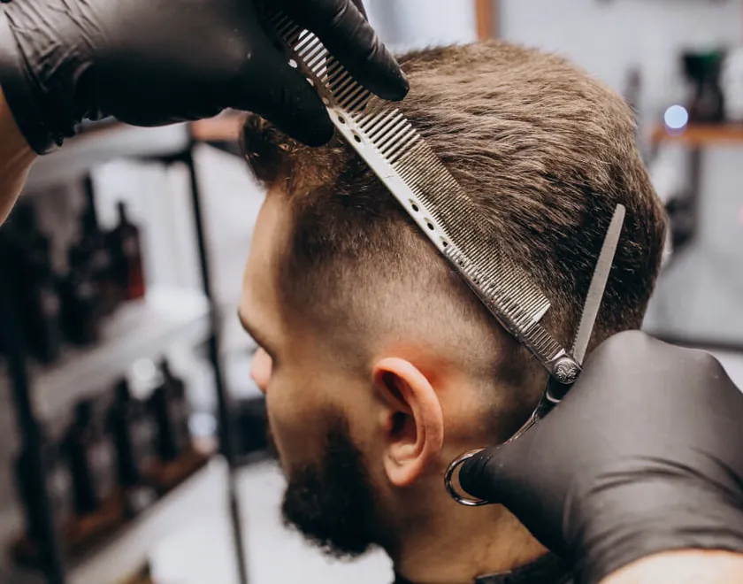 Barbiere che sistema i capelli con pettine